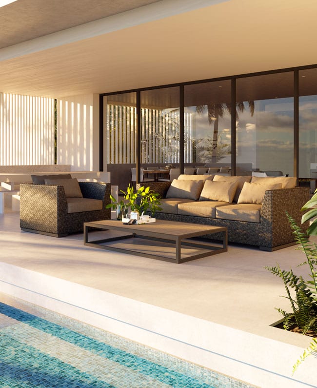 Outdoor furniture sofa set from Brown Jordan on a covered patio behind a modern-style luxury home facing the pool