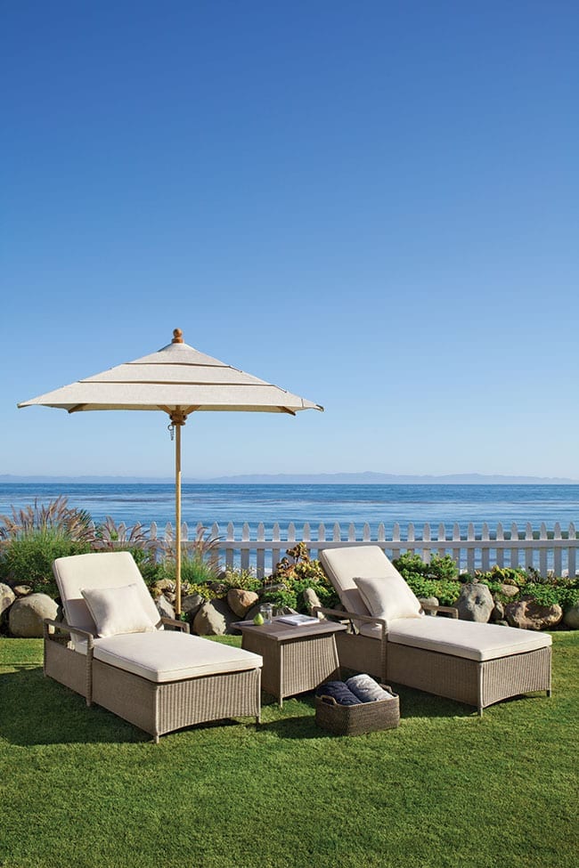 Outdoor furniture chaises set from the Southhampton collection from Brown Jordan on fenced-in yard with waterfront view