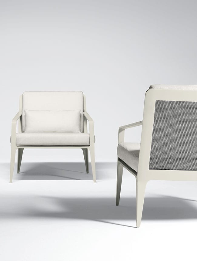 White patio chairs from Brown Jordan set up in a studio room with a white background
