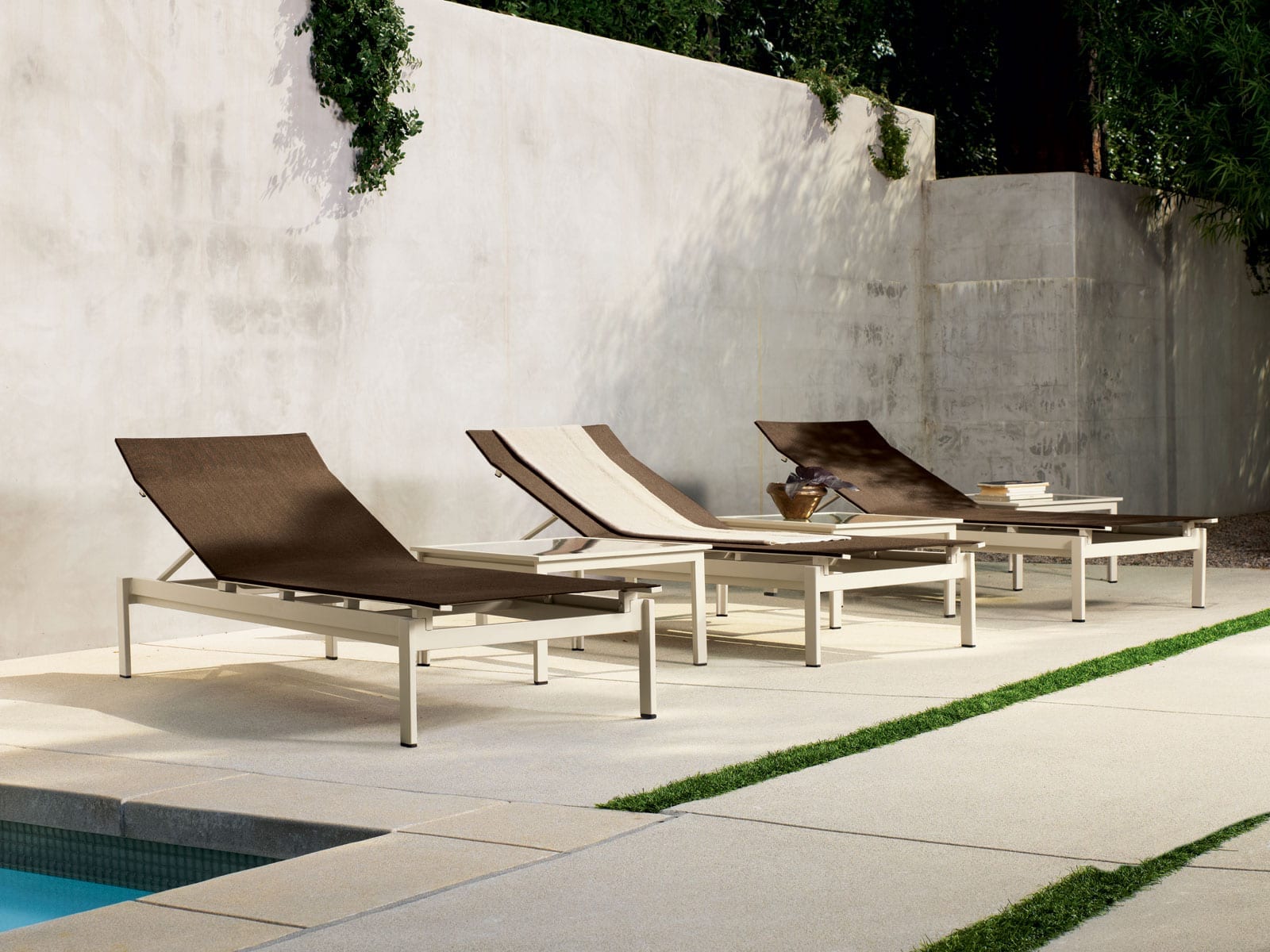 Swim outdoor furniture chaises from Brown Jordan on walled-in lanai next to a pool