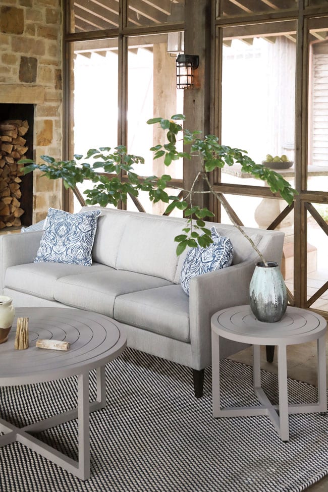 Finley upholstered sofa and other patio furniture from Lane Venture are set on screened-in lanai