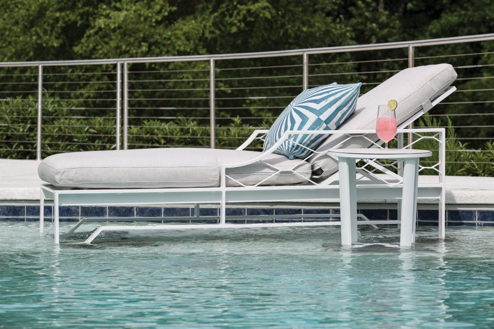Biscayne Bay chaise set from Lane Venture set up in the shallow end of the pool to keep cushions dry with a drink on the table