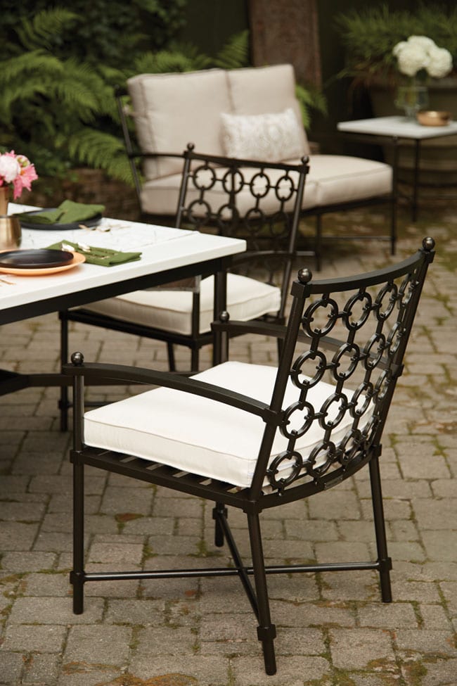 Langham dining chairs from Lane Venture purchased from Elegant Outdoor Living are set out on a patio made of stone pavers