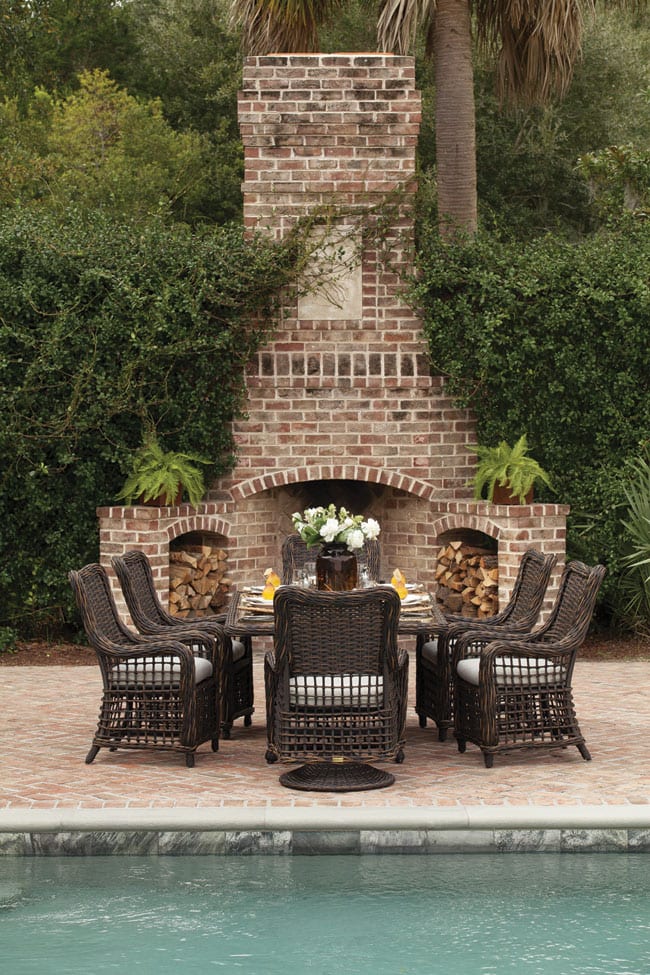 Moraya Bay wicker patio furniture dining set from Lane Venture on patio near pool and in front of brick fire place