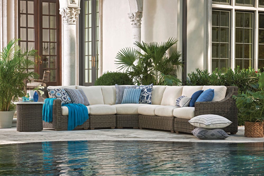 Oasis Sectional outdoor furniture on the patio facing the pool with art styles on throw pillows