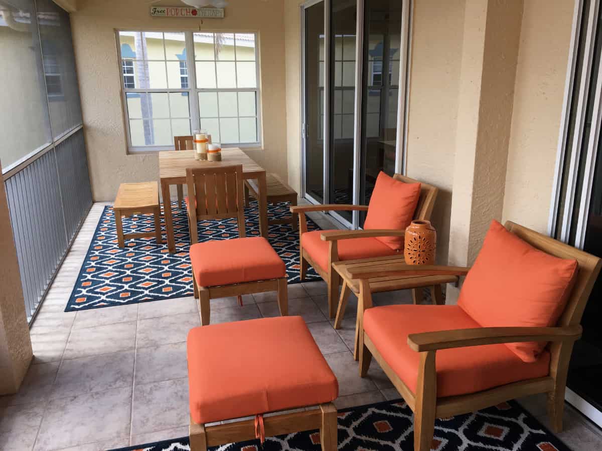 Classic Cushions dining table set and pair of lounge chairs with ottomans on back porch