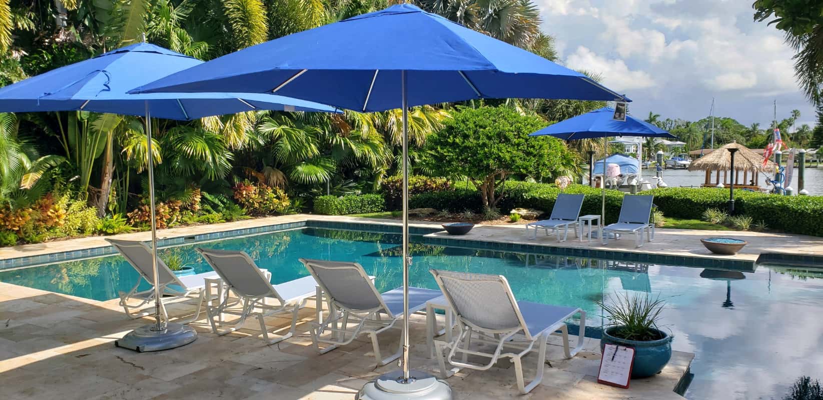 Tuuci chaise lounge chairs set under umbrella and facing the pool