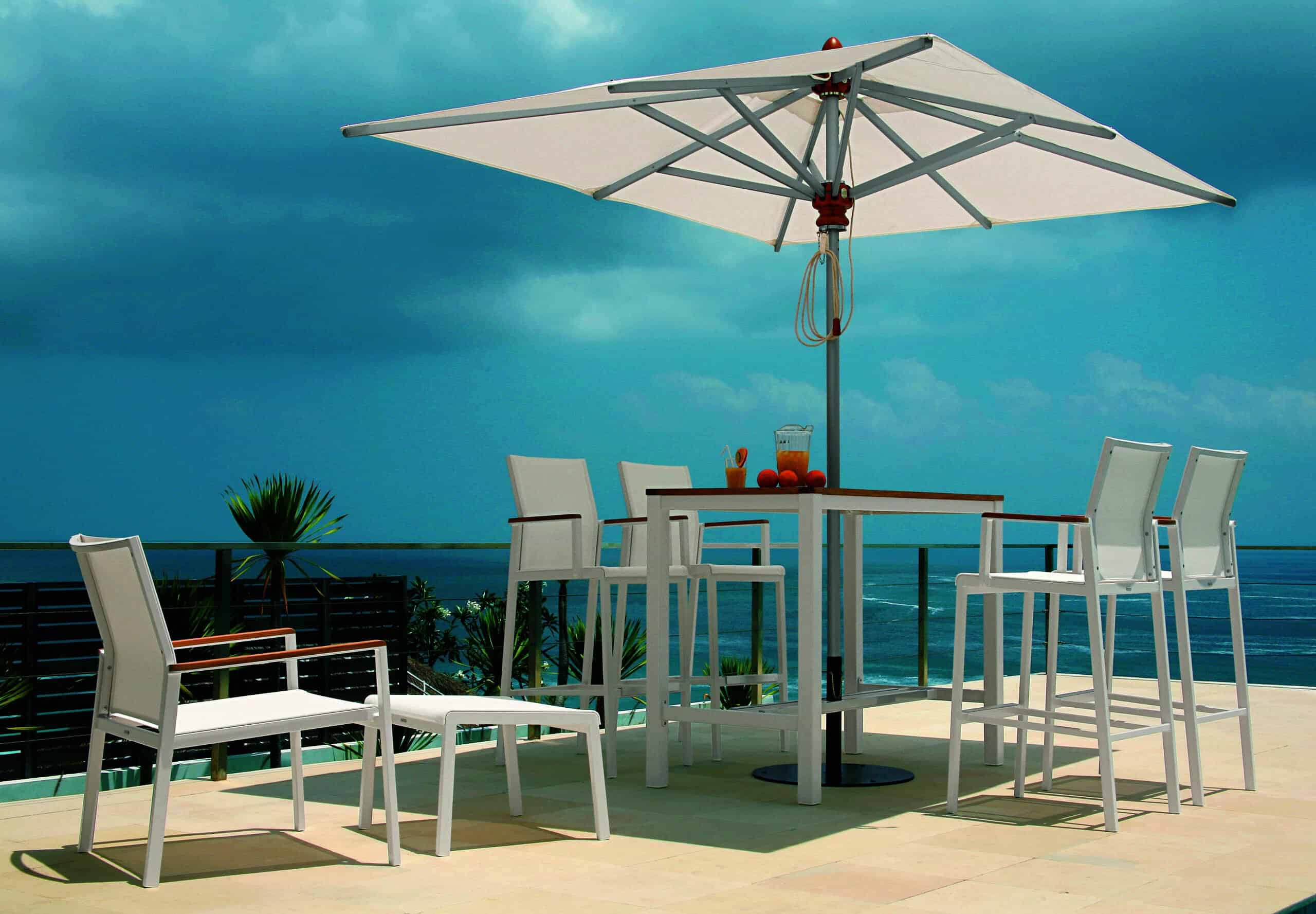 outdoor bar stools and table with umbrella overlooking a waterway background