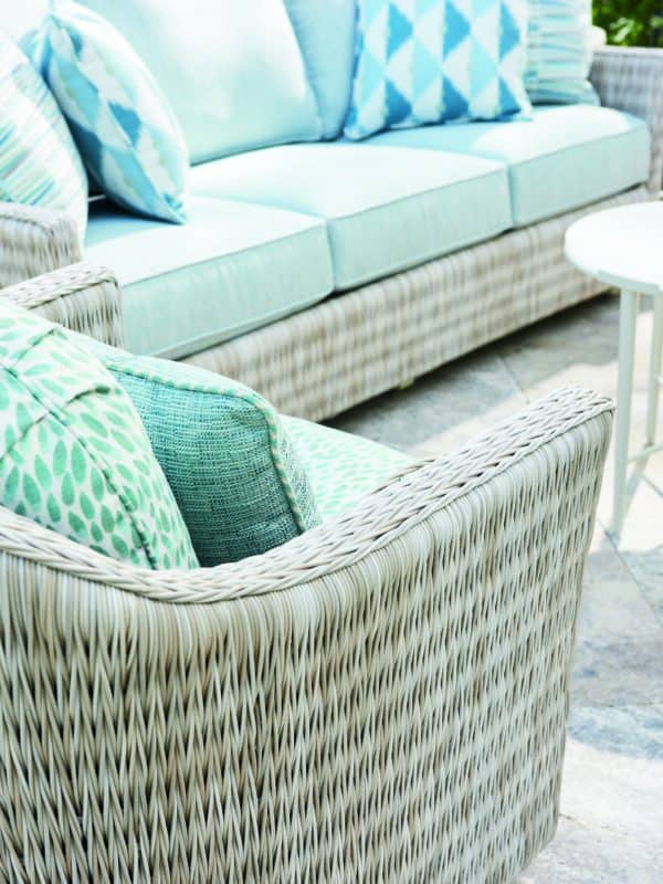 Image of a comfortable resin wicker glider and couch with cushions, perfect for relaxing outdoors.
